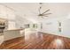 Bright living room with hardwood floors, ceiling fan, and access to the kitchen and outdoor space at 1559 Overland Dr, Spring Hill, FL 34608