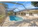 Clear, screened-in pool with concrete patio and views of the well-maintained backyard at 1559 Overland Dr, Spring Hill, FL 34608