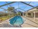 Inviting screened-in pool with a concrete deck, ladder, and access to outdoor living at 1559 Overland Dr, Spring Hill, FL 34608