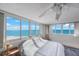 Bright bedroom with large windows offering panoramic ocean views and a ceiling fan at 17920 Gulf Blvd # 1103, Redington Shores, FL 33708