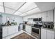 Bright kitchen features white cabinets, stainless steel appliances, granite counters, and tile floor at 17920 Gulf Blvd # 1103, Redington Shores, FL 33708