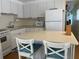 This kitchen features white cabinets and appliances and an island with seating for two at 27466 Us Highway 19 N # 32, Clearwater, FL 33761