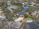 Aerial view of a charming home with a well-maintained lawn and a beautiful lake in a serene neighborhood at 2981 Northfield Dr, Tarpon Springs, FL 34688