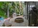 Cozy backyard featuring a grill, fire pit, outdoor seating, and mature trees perfect for entertaining and relaxation at 2981 Northfield Dr, Tarpon Springs, FL 34688