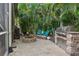 Charming backyard with grill, fire pit, seating, and mature trees creates a welcoming and functional outdoor living area at 2981 Northfield Dr, Tarpon Springs, FL 34688