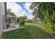 Expansive backyard with screened lanai, lush lawn, and mature trees offering a perfect space for outdoor activities at 2981 Northfield Dr, Tarpon Springs, FL 34688