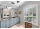 Bright bathroom with double sink vanity, granite countertops, custom cabinetry, large mirror, and arched window with plantation shutters at 2981 Northfield Dr, Tarpon Springs, FL 34688