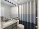 Bathroom showcasing a granite countertop vanity and a stylish blue and white shower curtain at 2981 Northfield Dr, Tarpon Springs, FL 34688