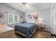 Bedroom with light blue walls, wood floors, ceiling fan, a double bed, and large window with plantation shutters at 2981 Northfield Dr, Tarpon Springs, FL 34688