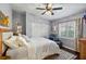 Bedroom featuring white bedding, hardwood floors, a ceiling fan, and a window with plantation shutters at 2981 Northfield Dr, Tarpon Springs, FL 34688