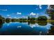 Scenic lake view with clear reflections of the sky, clouds, and surrounding trees, offering a tranquil and picturesque setting at 2981 Northfield Dr, Tarpon Springs, FL 34688