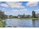 Peaceful lake view with blue sky and clouds, complemented by lush green lawns and mature trees along the shoreline at 2981 Northfield Dr, Tarpon Springs, FL 34688