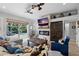Stylish living room featuring a stone fireplace, TV, and sliding glass doors to outdoor pool area at 2981 Northfield Dr, Tarpon Springs, FL 34688