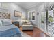 Bright main bedroom featuring hardwood floors, cozy sitting area with chair, ottoman, and a private outdoor view at 2981 Northfield Dr, Tarpon Springs, FL 34688