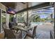 Covered outdoor dining area featuring a dining table, wicker chairs, grill, and view of the pool and backyard at 2981 Northfield Dr, Tarpon Springs, FL 34688