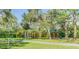 Community playground with colorful play structures including slides and swings, surrounded by lush trees and greenery at 2981 Northfield Dr, Tarpon Springs, FL 34688