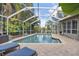Sparkling screened-in pool surrounded by brick pavers and lush landscaping at 2981 Northfield Dr, Tarpon Springs, FL 34688