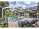Refreshing screened-in pool with brick patio, lounge chairs, and well-manicured landscaping providing a relaxing retreat at 2981 Northfield Dr, Tarpon Springs, FL 34688