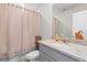 Bathroom featuring a light gray vanity with granite countertop, a large mirror, and a shower with patterned curtain at 3224 Fresno Pl, Zephyrhills, FL 33541