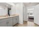 A bathroom with a double sink vanity, tile floors, and a door that leads to the bedroom at 3224 Fresno Pl, Zephyrhills, FL 33541
