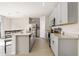 A kitchen with gray cabinets, an island, stainless steel appliances and white countertops at 3224 Fresno Pl, Zephyrhills, FL 33541