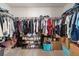 Spacious walk-in closet with ample hanging space, shelving for shoes, and storage boxes for optimal organization at 3224 Fresno Pl, Zephyrhills, FL 33541