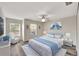 Bright bedroom with gray flooring, three windows, ceiling fan, and a bed with white accents at 3870 Island Way, St Petersburg, FL 33705