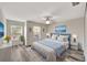 Bedroom with gray flooring, three windows, ceiling fan, and a bed with blue accents at 3870 Island Way, St Petersburg, FL 33705