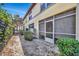 Exterior of a yellow townhome featuring a screened patio, landscaping, and black fence at 3870 Island Way, St Petersburg, FL 33705