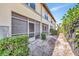 Exterior view of a yellow townhome with screened patio, landscaping, and a black fence at 3870 Island Way, St Petersburg, FL 33705