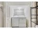 Functional laundry space equipped with a washer, dryer, and shelving at 3870 Island Way, St Petersburg, FL 33705