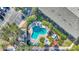 An aerial view of the free-form pool with surrounding lounge seating, a hot tub, and mature landscaping at 3870 Island Way, St Petersburg, FL 33705