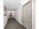 A hallway with carpet and white walls leads to unit entrance with a door knocker and unit number at 400 Island Way # 911, Clearwater Beach, FL 33767