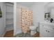 Bright bathroom featuring a shower with a floral curtain, wood-look flooring, and a white single sink vanity at 4191 39Th S St, St Petersburg, FL 33711