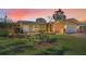 Charming home with a well-maintained lawn and brick garden bed, highlighted by a picturesque sunset sky at 4191 39Th S St, St Petersburg, FL 33711