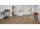 Open-concept living room with a kitchen area, laminate flooring, and a workspace at 4191 39Th S St, St Petersburg, FL 33711