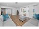 Bright living room featuring new wood flooring, light gray sofas, and large windows at 4191 39Th S St, St Petersburg, FL 33711