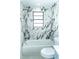 Bathroom featuring a tub/shower combo with marble-look tile and brushed nickel hardware at 4222 Autumn Leaves Dr, Tampa, FL 33624