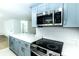 Modern kitchen with stainless steel microwave and oven, quartz countertops, and gray cabinets at 4222 Autumn Leaves Dr, Tampa, FL 33624