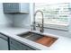 Close up of a stainless steel sink, quartz countertops, and gray cabinets in a modern kitchen at 4222 Autumn Leaves Dr, Tampa, FL 33624