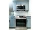 Modern kitchen with stainless steel oven, range, quartz countertops, and gray cabinets at 4222 Autumn Leaves Dr, Tampa, FL 33624