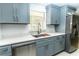 Updated kitchen featuring modern stainless steel appliances, gray cabinets, and quartz countertops at 4222 Autumn Leaves Dr, Tampa, FL 33624