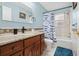 Bathroom with tiled floor, wooden vanity with granite countertop, and shower/tub combo with fish-themed curtain at 4407 Parnell Dr, Sarasota, FL 34232