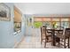 A sun-drenched breakfast nook with tiled floors, natural window shades and a white door to the outside at 4407 Parnell Dr, Sarasota, FL 34232