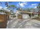Exterior shot of the home with a fenced drive-through gate and a boat in the driveway at 4407 Parnell Dr, Sarasota, FL 34232
