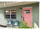 A close-up shot of the front porch with seating and a charming pink front door at 4407 Parnell Dr, Sarasota, FL 34232