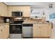 Modern kitchen with stainless steel oven, microwave and dishwasher and wood cabinets at 4407 Parnell Dr, Sarasota, FL 34232