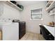 Functional laundry room with a washer, dryer, built-in shelves, a window and an office space at 4407 Parnell Dr, Sarasota, FL 34232