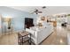 Cozy living area with a soft blue accent wall, tile flooring, and a comfortable white sectional sofa at 4407 Parnell Dr, Sarasota, FL 34232