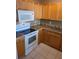 Kitchen featuring white appliances, oak cabinets, and tiled countertops at 5125 Palm Springs Blvd # 1101, Tampa, FL 33647